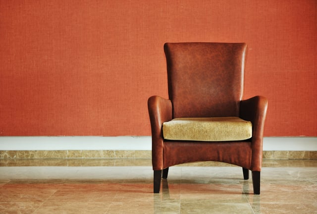 vintage brown-gray chair standing beside the wall