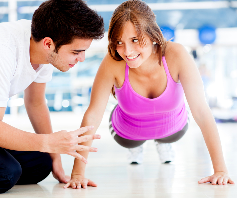 Woman exercising at the gym with her personal trainer