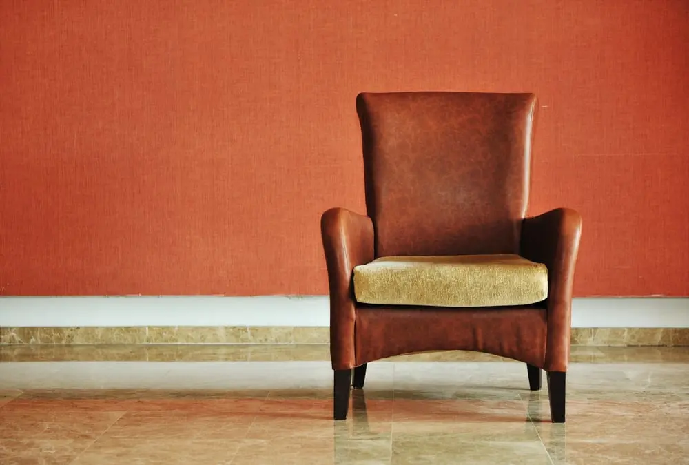 vintage brown-gray chair standing beside the wall_compressed